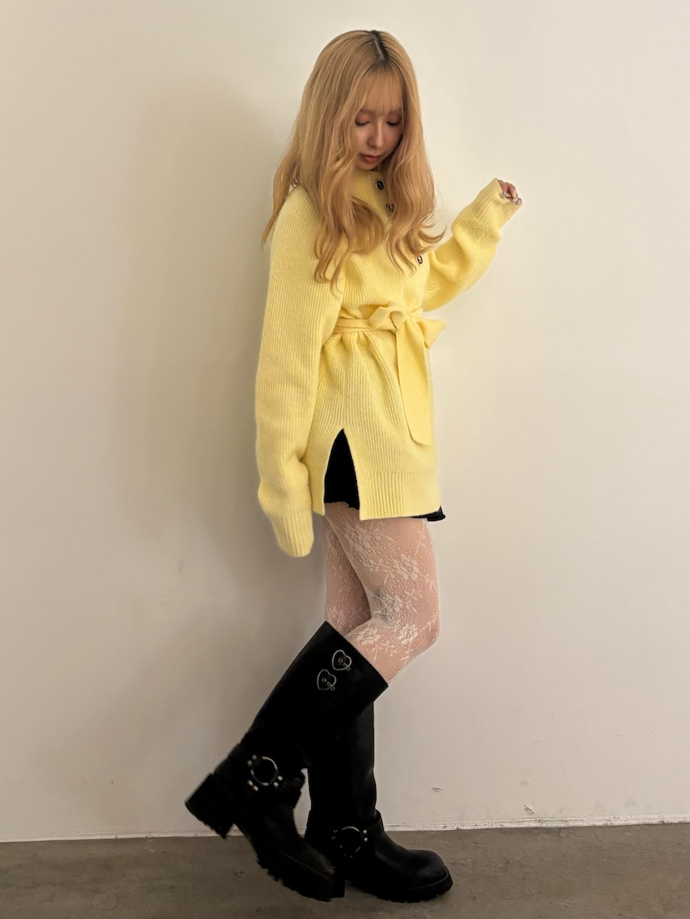 イエロー系のニット/セーター、ブラック系のその他パンツ、ブラック系のブーツを着用したレディースの秋コーディネートの2枚目の写真