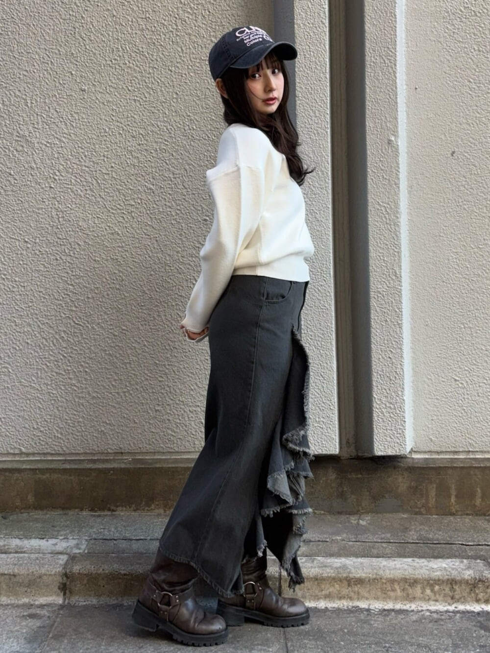 ホワイト系のニット/セーター、ブラック系のスカート、ブラック系のキャップを着用したレディースの冬コーディネートの4枚目の写真