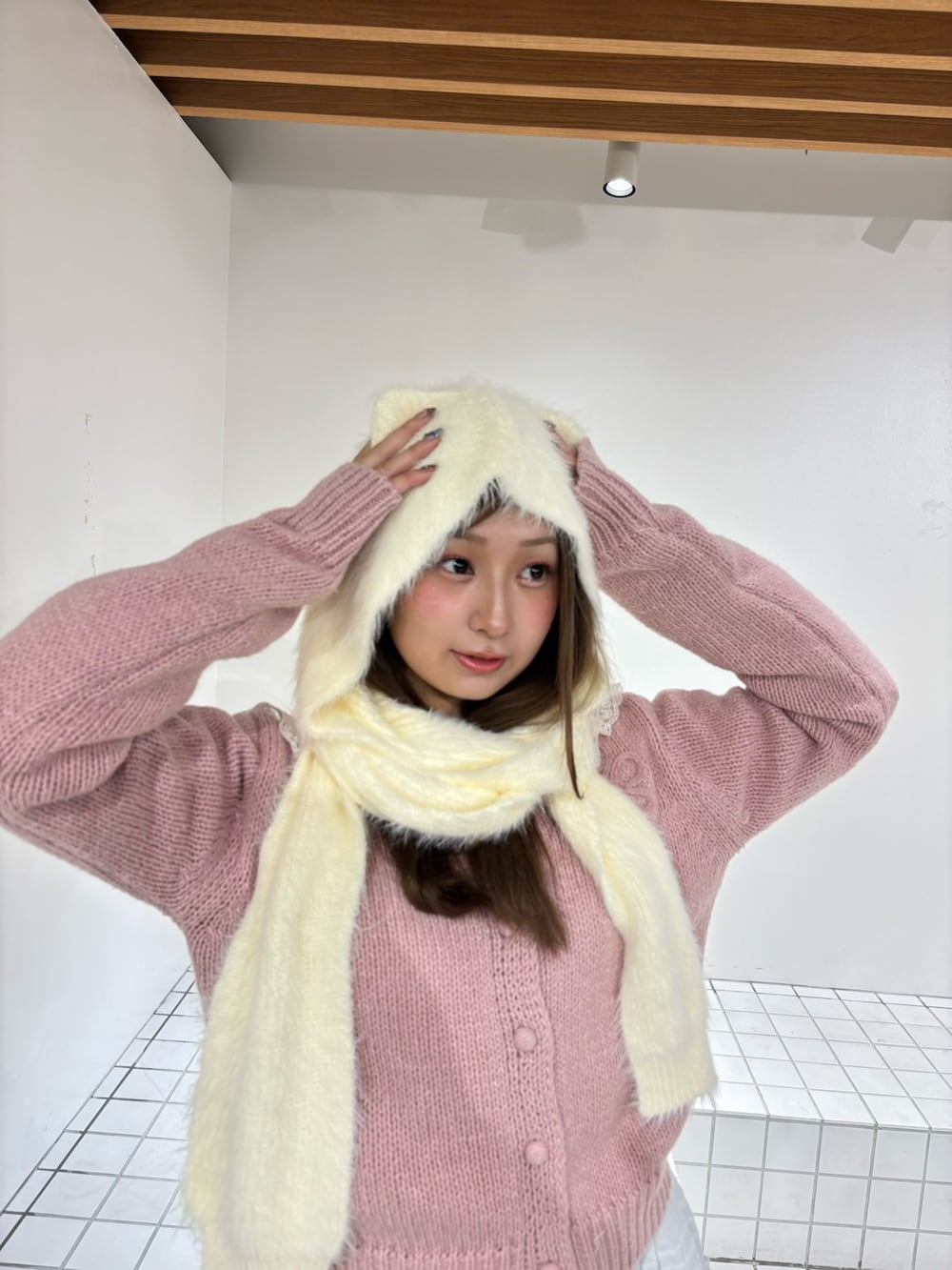 ホワイト系のスカート、ピンク系のニット/セーター、ホワイト系のTシャツ/カットソーを着用したレディースの秋コーディネートの4枚目の写真