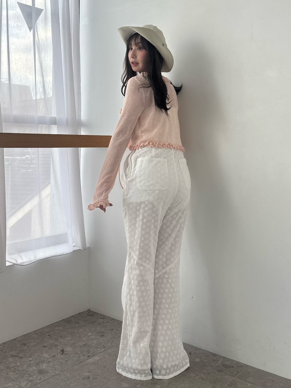 ホワイト系のつなぎ/オールインワン、ピンク系のニット/セーター、ブラウン系のサンダルを着用したレディースの春コーディネートの4枚目の写真