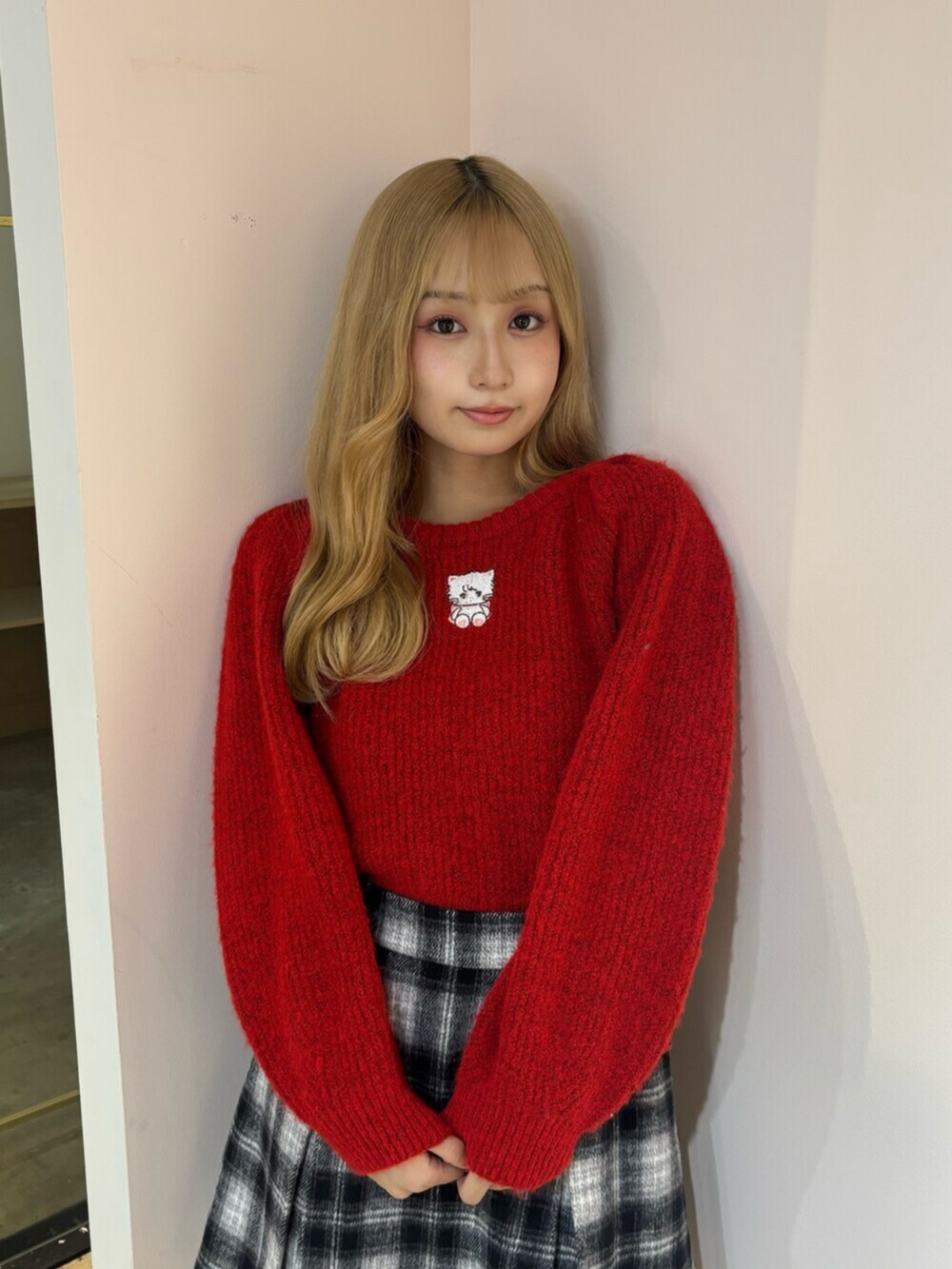 ブラック系のブーツ、レッド系のニット/セーター、その他のスカートを着用したレディースの秋コーディネートの5枚目の写真