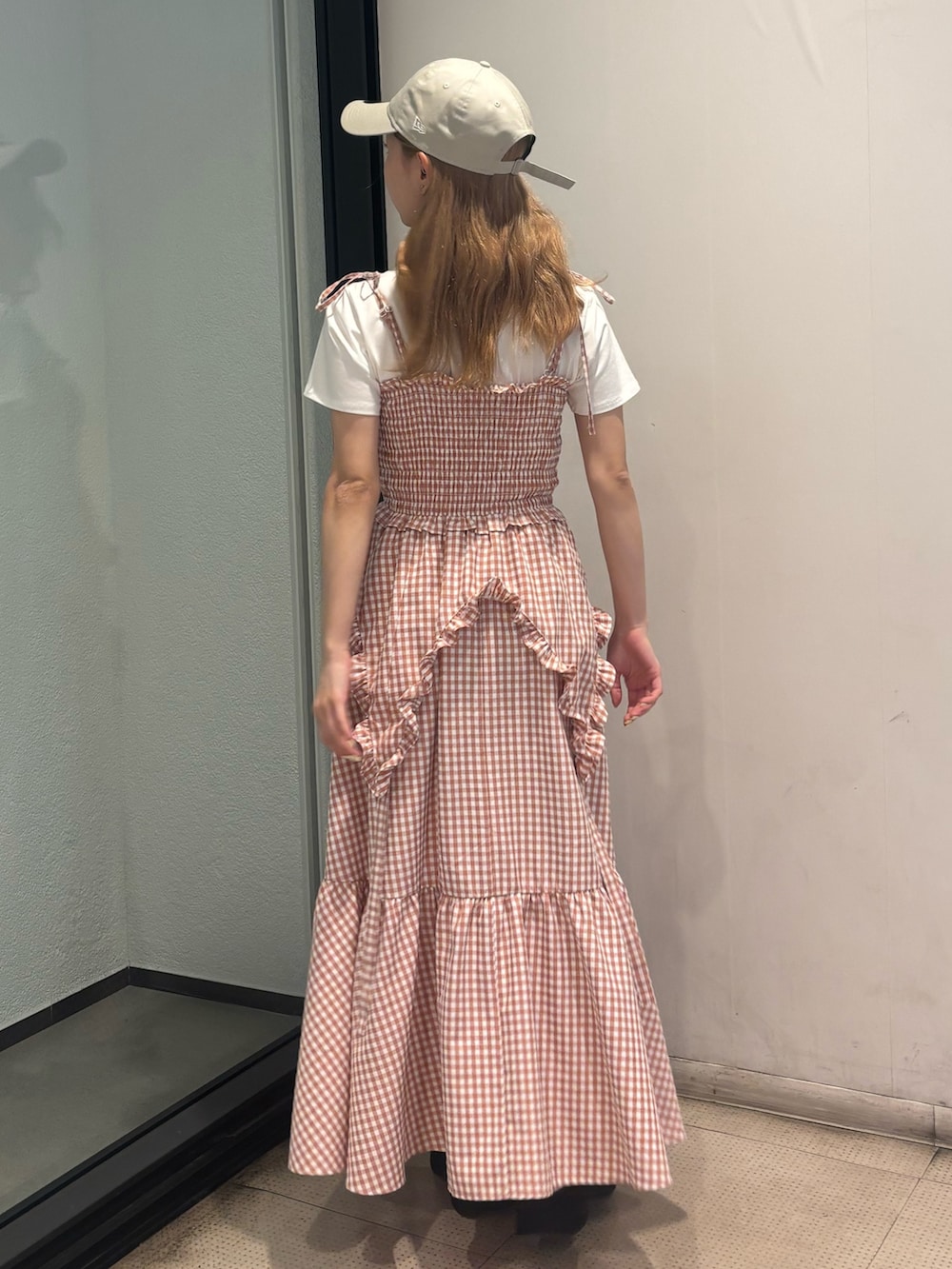 ピンク系のワンピース、ホワイト系のTシャツ/カットソー、ホワイト系のサンダルを着用したレディースの夏コーディネートの3枚目の写真