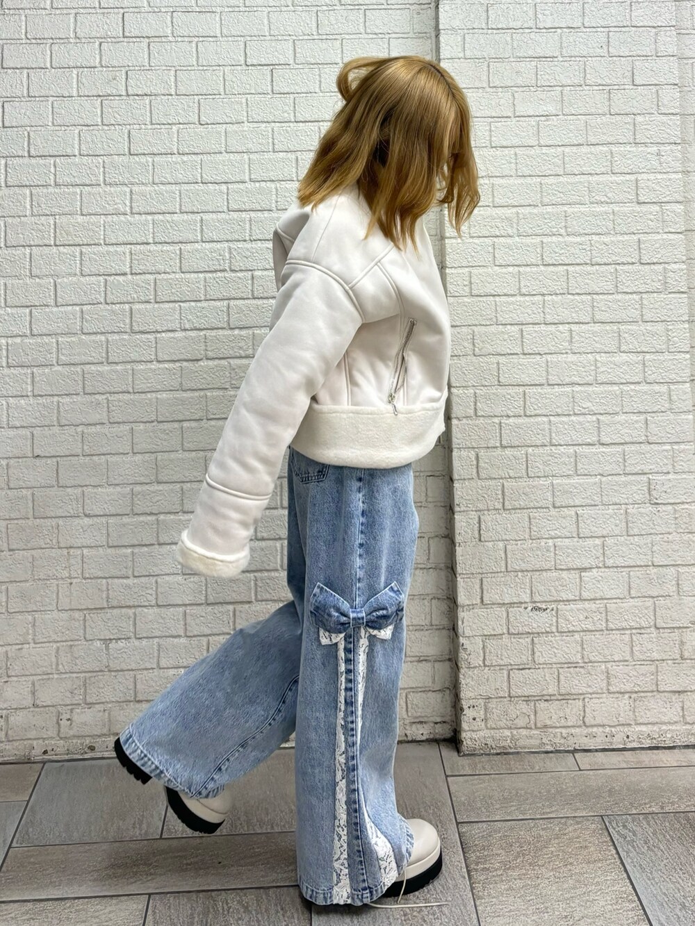 その他のブルゾン、ブルー系のデニムパンツ、ブラック系のブーツを着用したレディースの秋コーディネートの3枚目の写真