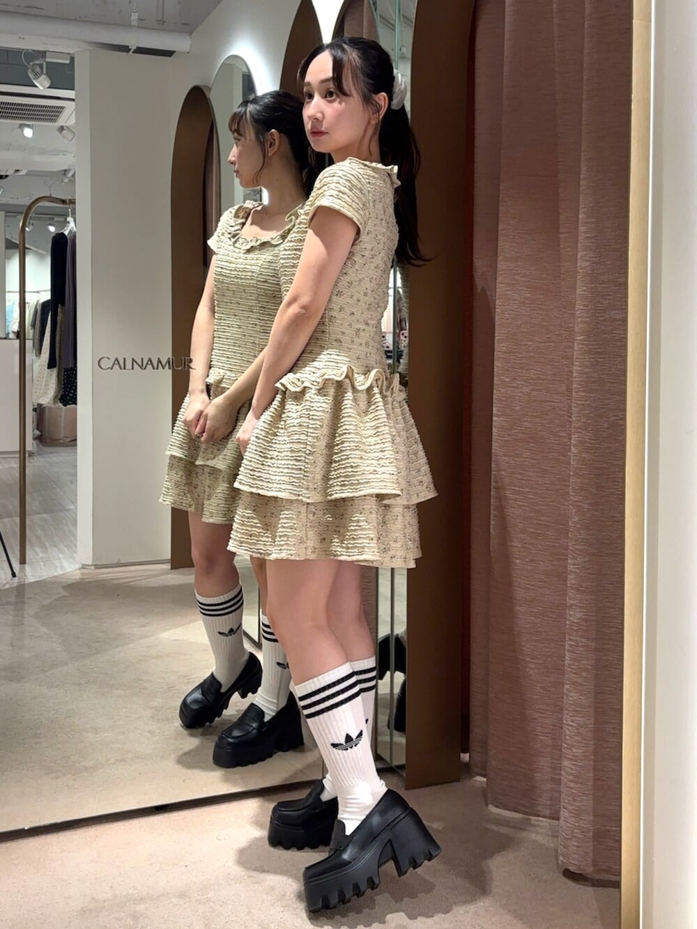 ベージュ系のワンピースを着用したレディースの春コーディネートの2枚目の写真