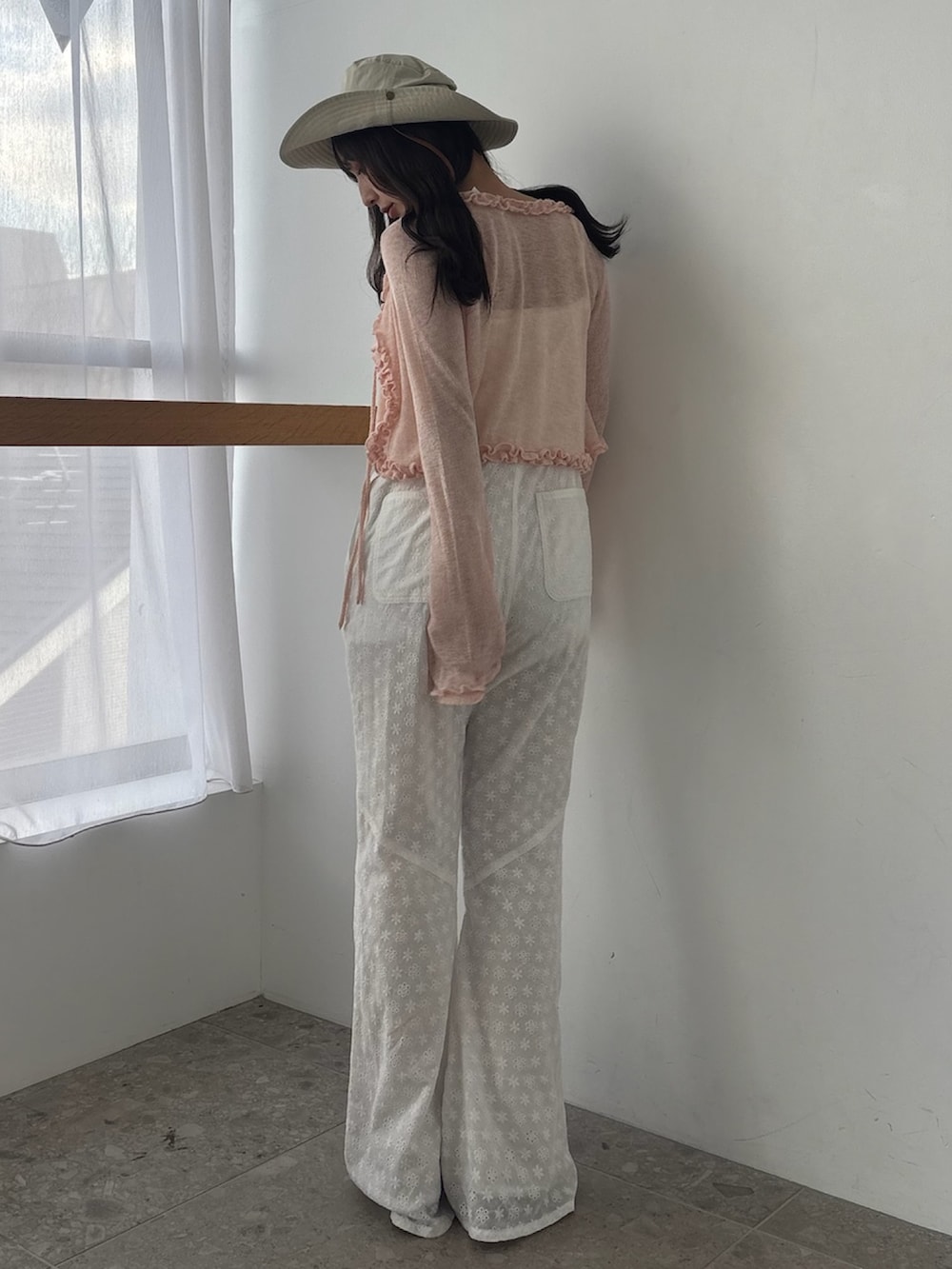 ホワイト系のつなぎ/オールインワン、ピンク系のニット/セーター、ブラウン系のサンダルを着用したレディースの春コーディネートの3枚目の写真