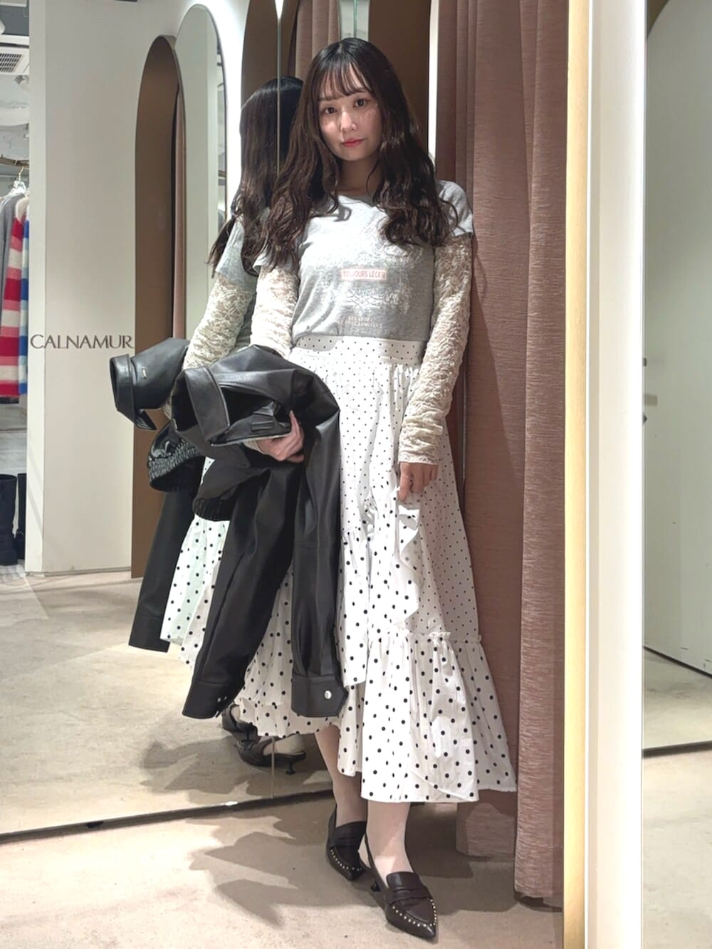 ブラウン系のブルゾン、ホワイト系のスカート、ブラウン系のサンダルを着用したレディースの春コーディネートの5枚目の写真