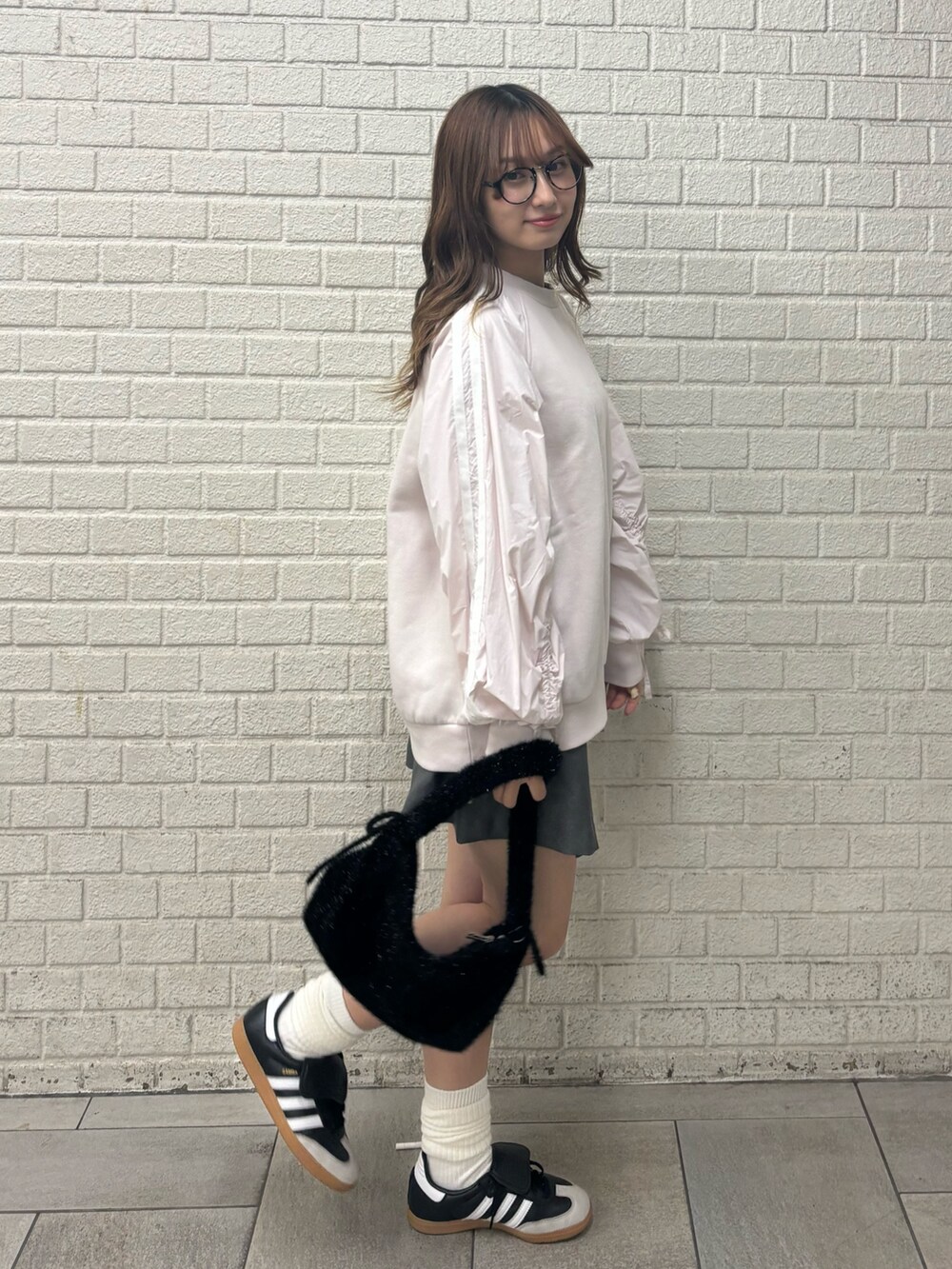 ピンク系のスウェット、グレー系のスカートを着用したレディースの秋コーディネートの4枚目の写真