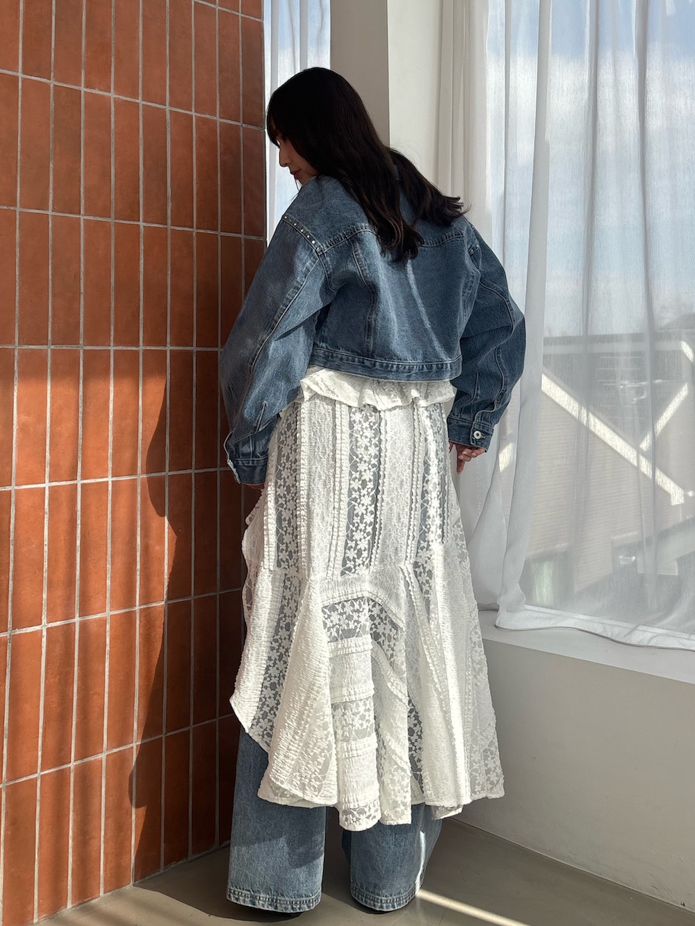 ホワイト系のワンピース、ブルー系のデニムジャケット、ブルー系のその他パンツを着用したレディースの冬コーディネートの3枚目の写真