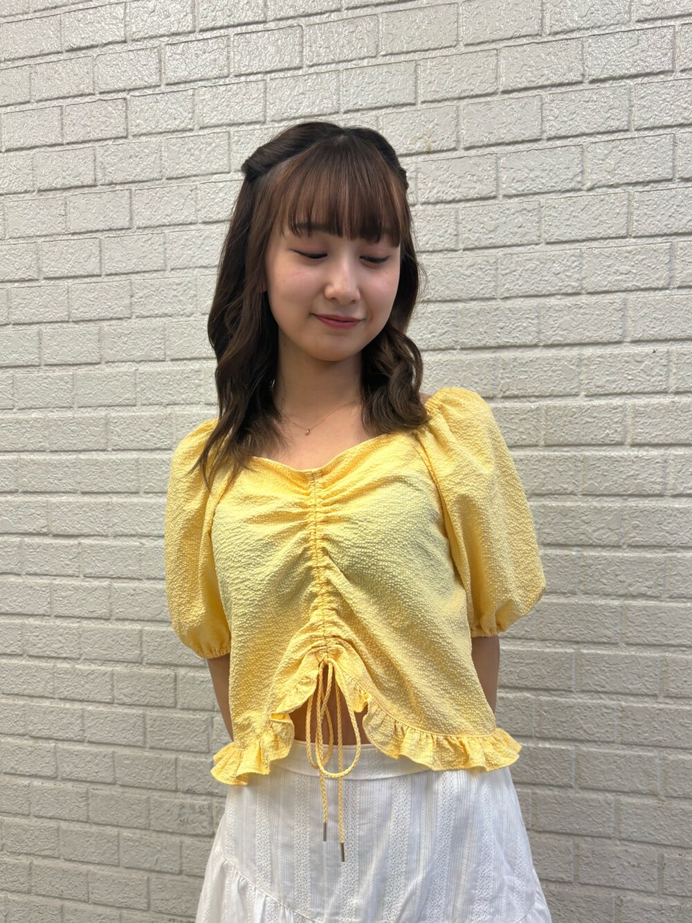 ホワイト系のスカート、イエロー系のシャツ/ブラウス、イエロー系のサンダルを着用したレディースの春コーディネートの4枚目の写真