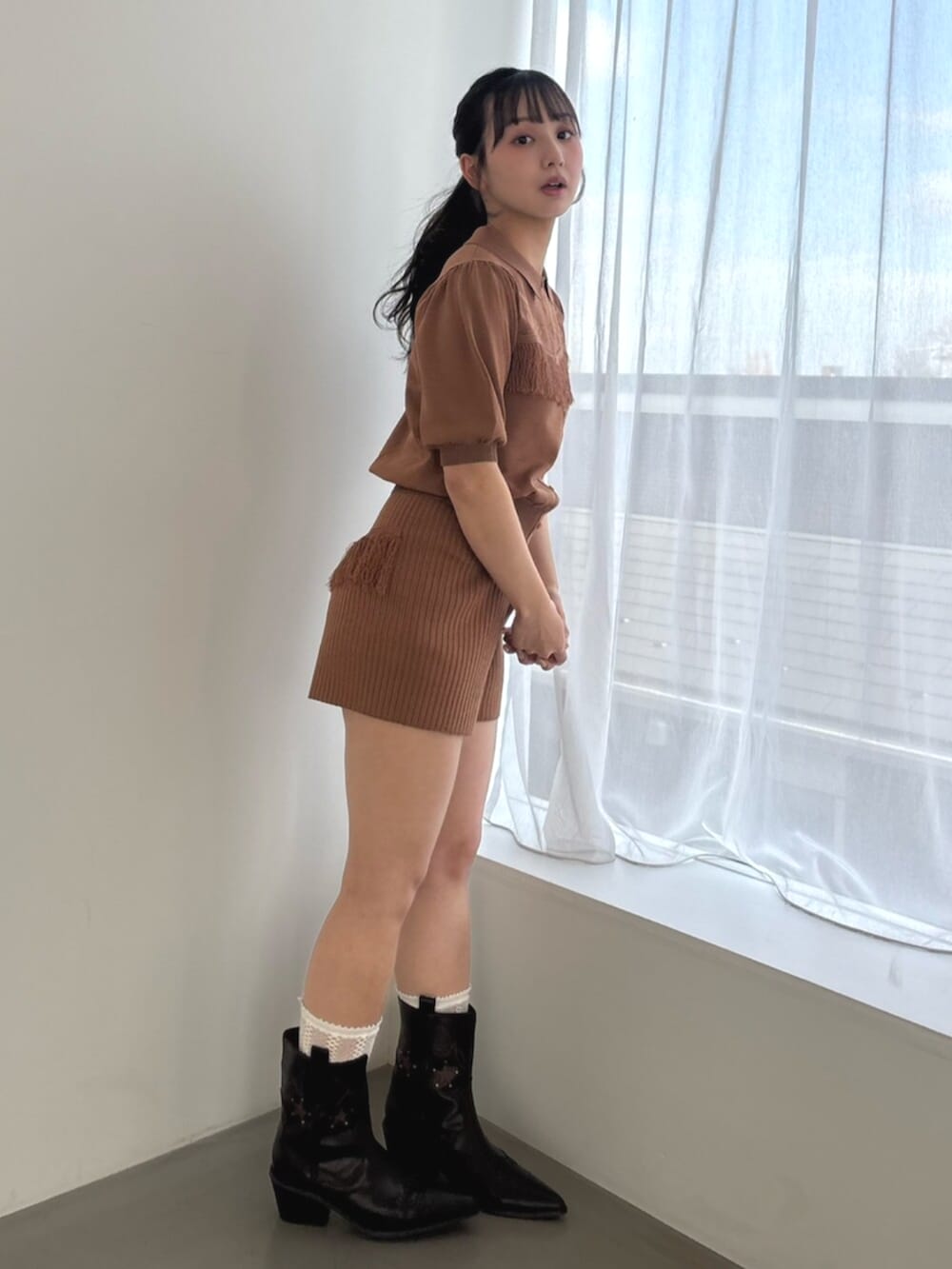 ブラウン系のその他パンツ、ブラウン系のニット/セーター、ブラック系のブーツを着用したレディースの春コーディネートの2枚目の写真