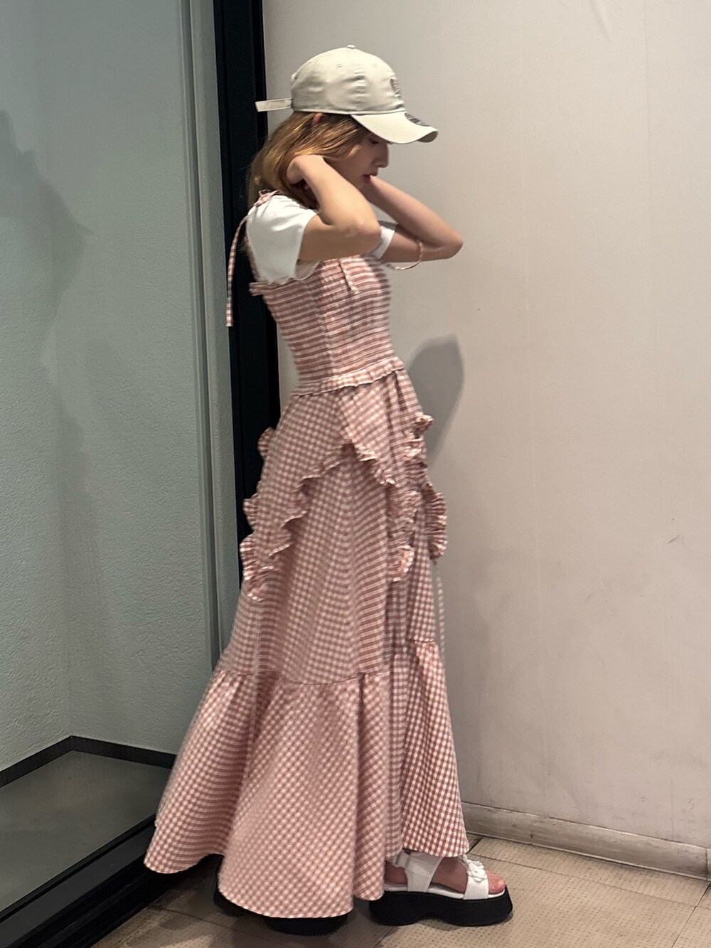 ピンク系のワンピース、ホワイト系のTシャツ/カットソー、ホワイト系のサンダルを着用したレディースの夏コーディネートの2枚目の写真