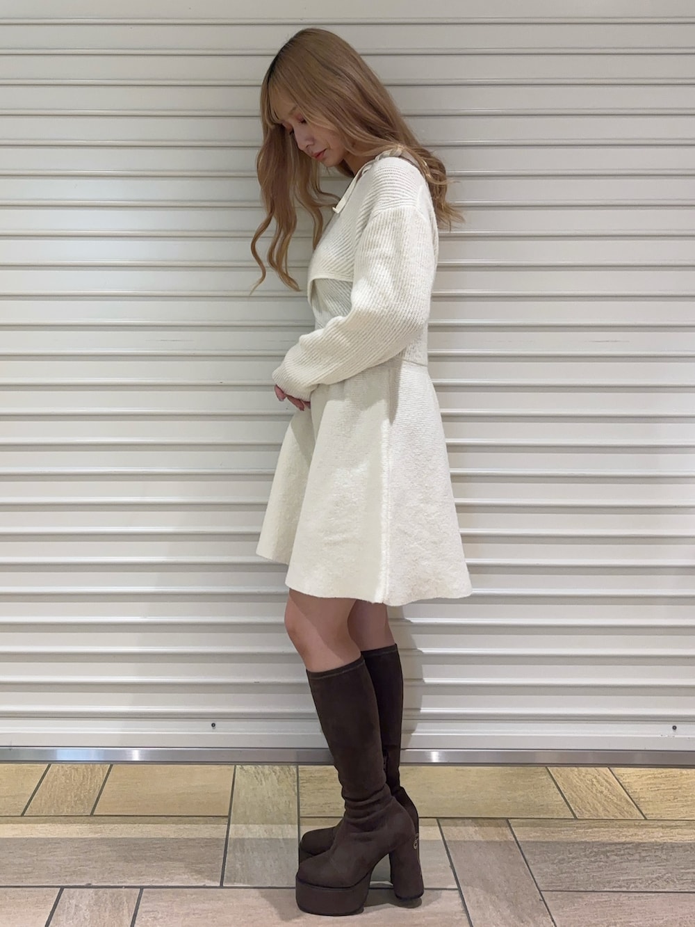 ホワイト系のワンピース、ブラウン系のブーツを着用したレディースの秋コーディネートの2枚目の写真