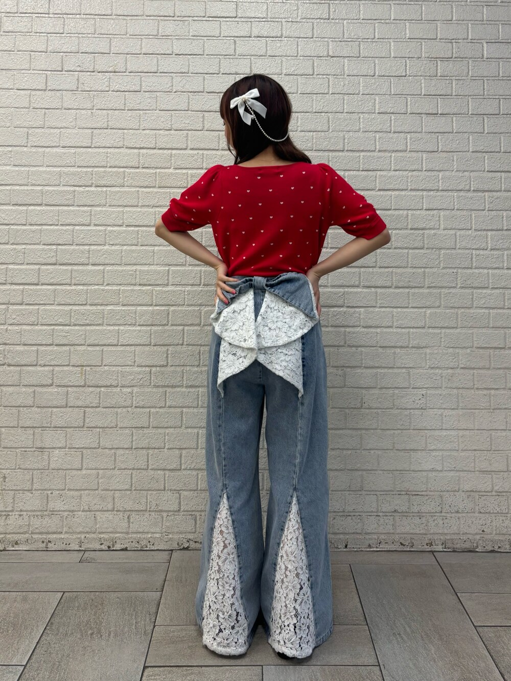 ブルー系のデニムパンツ、レッド系のニット/セーター、ブラック系のバレッタ/ヘアクリップを着用したレディースの夏コーディネートの3枚目の写真