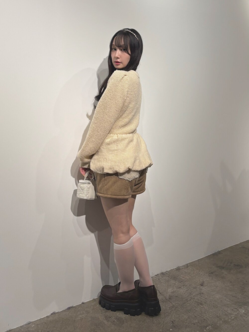 ブラウン系のローファー、ベージュ系のその他パンツ、ホワイト系のニット/セーターを着用したレディースの秋コーディネートの2枚目の写真