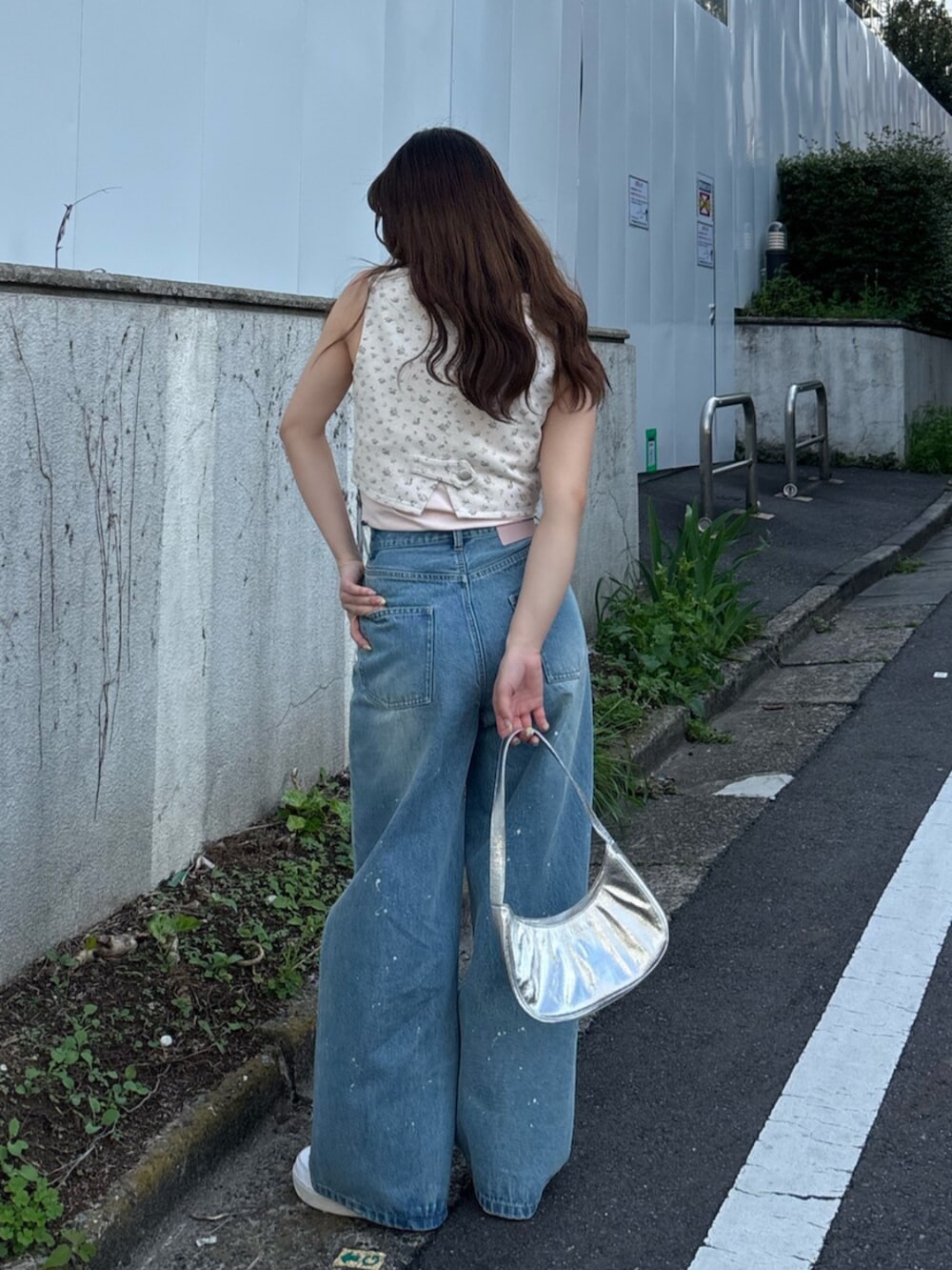 ピンク系のベスト、ピンク系のキャミソール、ブルー系のデニムパンツを着用したレディースの春コーディネートの4枚目の写真