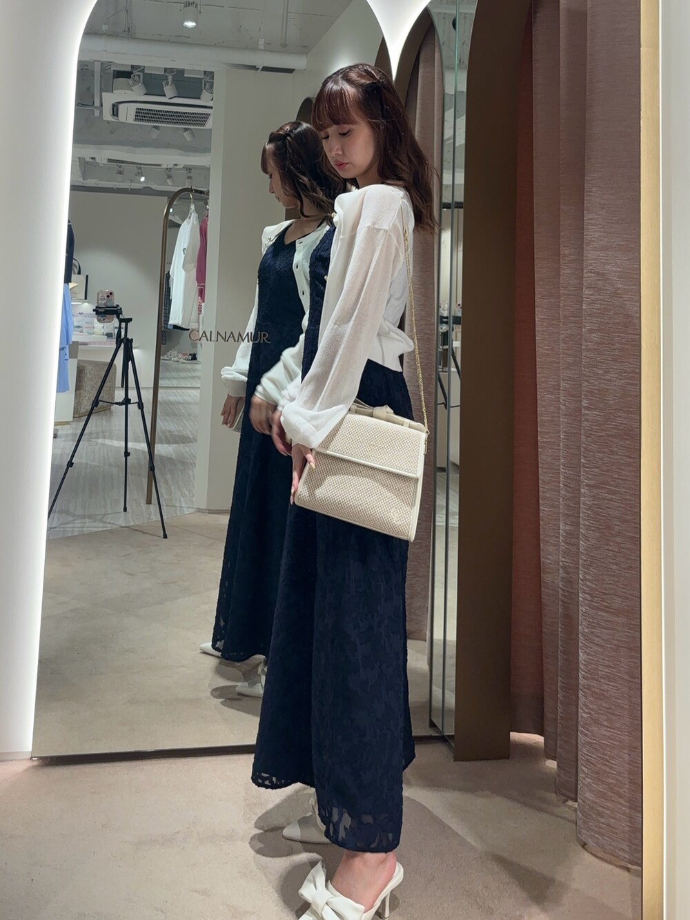 ブルー系のつなぎ/オールインワン、ホワイト系のカーディガン/ボレロ、ホワイト系のハンドバッグを着用したレディースの夏コーディネートの3枚目の写真