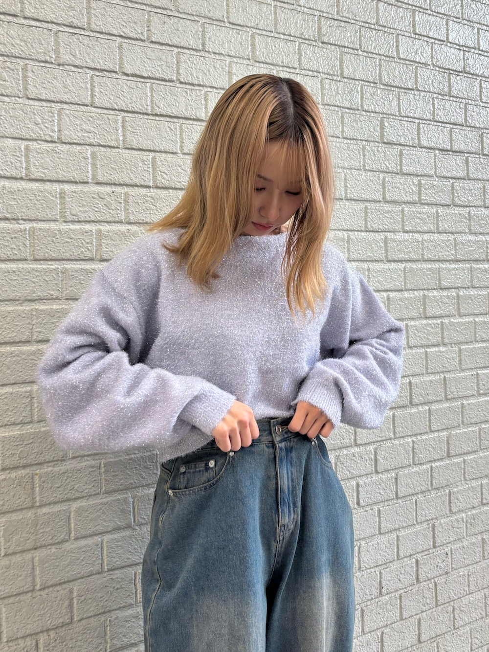 ブルー系のデニムパンツ、パープル系のニット/セーターを着用したレディースの冬コーディネートの6枚目の写真