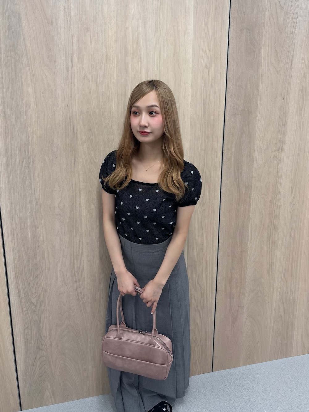 グレー系のスカート、ブラック系のTシャツ/カットソー、ピンク系のボストンバッグを着用したレディースの夏コーディネートの4枚目の写真