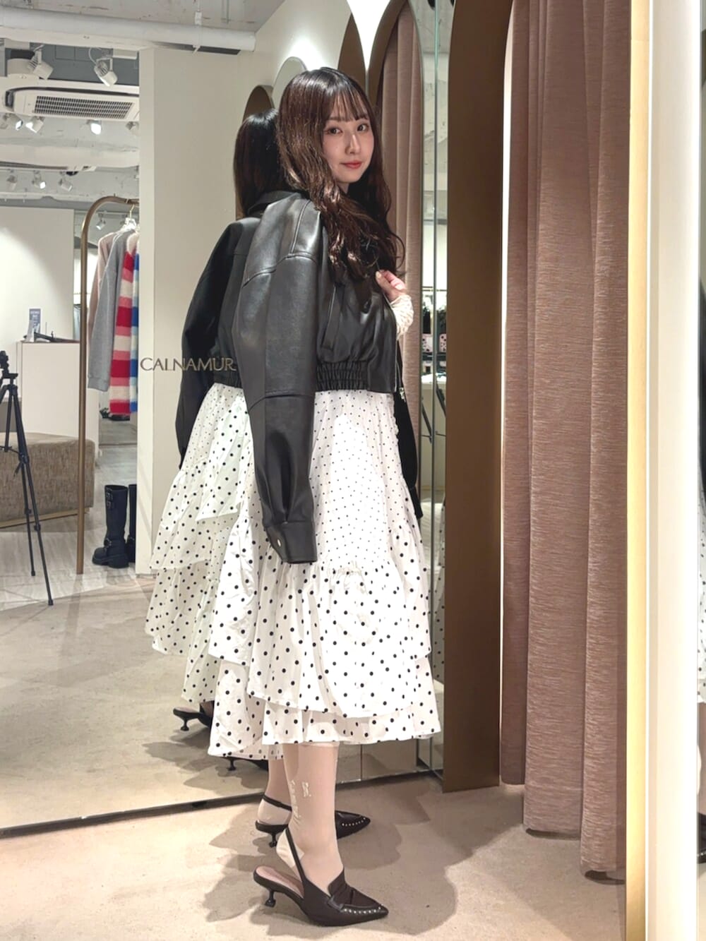 ブラウン系のブルゾン、ホワイト系のスカート、ブラウン系のサンダルを着用したレディースの春コーディネートの4枚目の写真