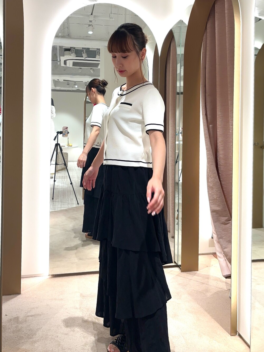 ホワイト系のカーディガン/ボレロ、イエロー系のサンダル、ホワイト系のスカートを着用したレディースの春コーディネートの2枚目の写真