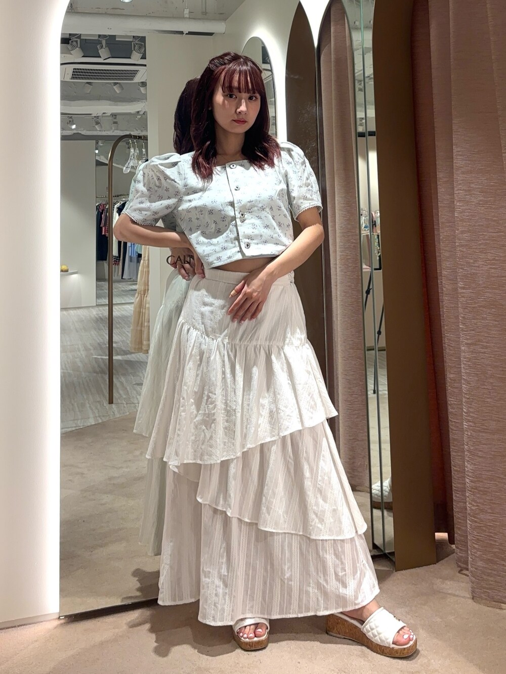 ホワイト系のスカート、ブルー系のシャツ/ブラウスを着用したレディースの春コーディネートの2枚目の写真