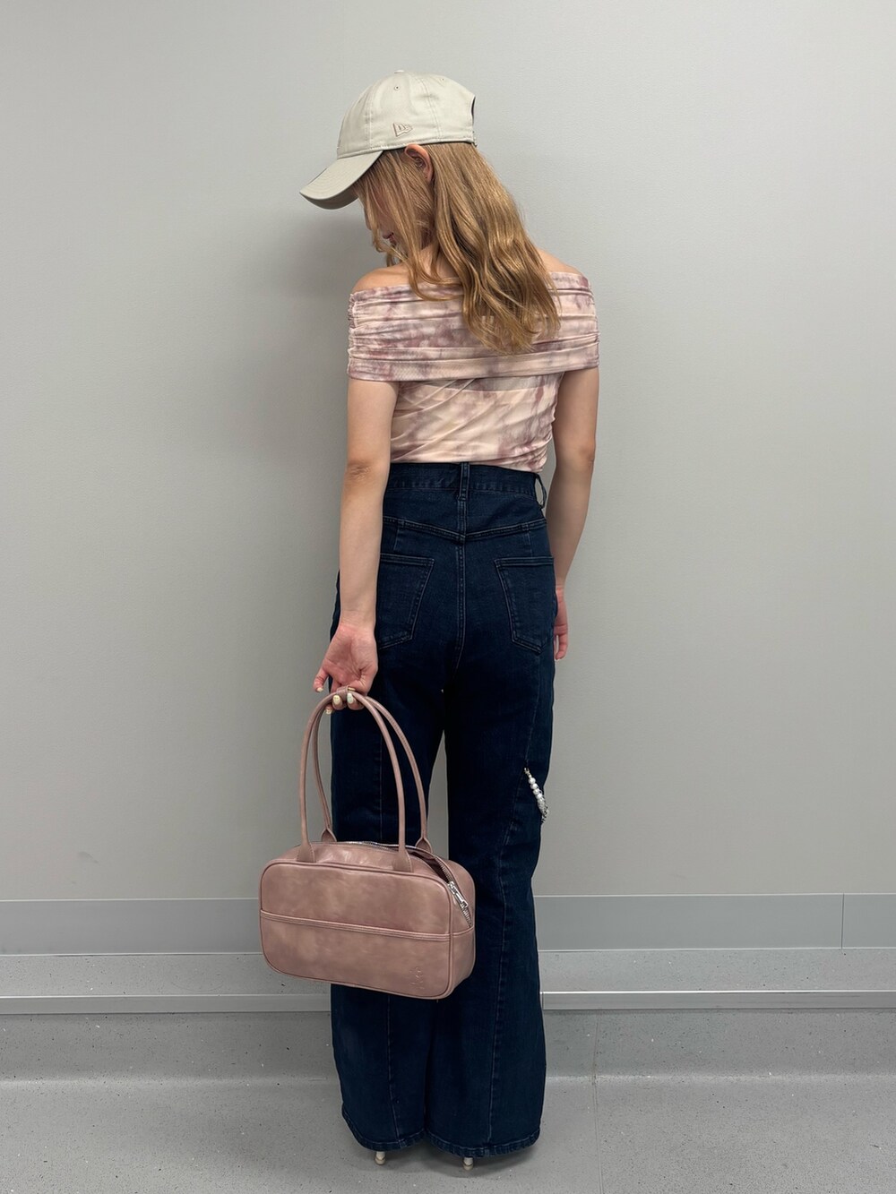 ブルー系のデニムパンツ、ピンク系のTシャツ/カットソー、ピンク系のボストンバッグを着用したレディースの夏コーディネートの3枚目の写真