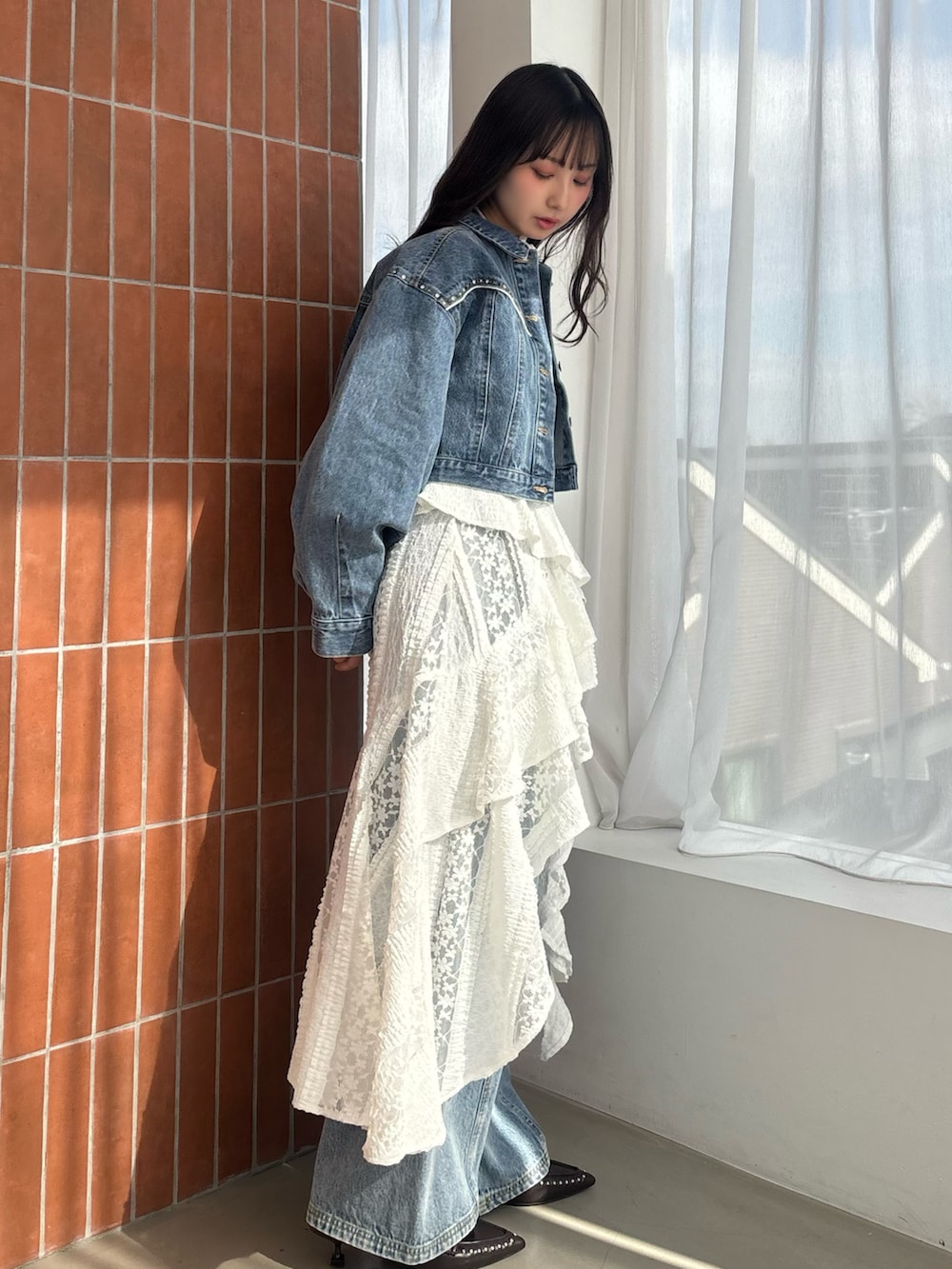 ホワイト系のワンピース、ブルー系のデニムジャケット、ブルー系のその他パンツを着用したレディースの冬コーディネートの2枚目の写真