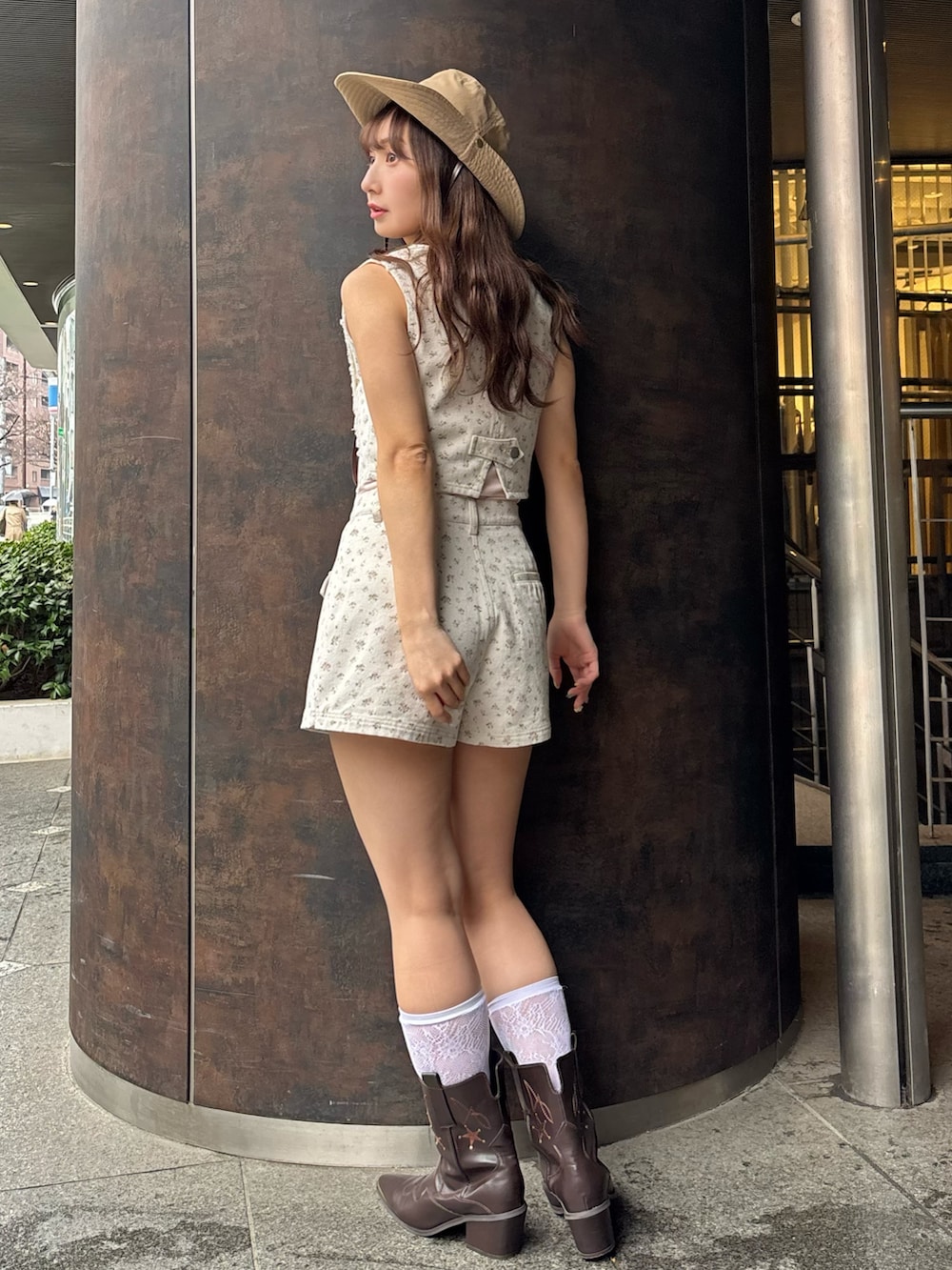 ピンク系のベスト、ピンク系のスカート、ピンク系のキャミソールを着用したレディースの春コーディネートの3枚目の写真