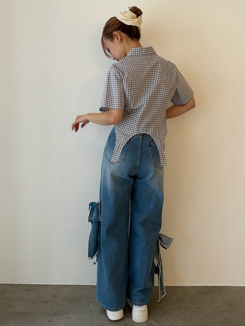 グレー系のシャツ/ブラウス、ブルー系のデニムパンツ、ホワイト系のサンダルを着用したレディースの春コーディネートの3枚目の写真