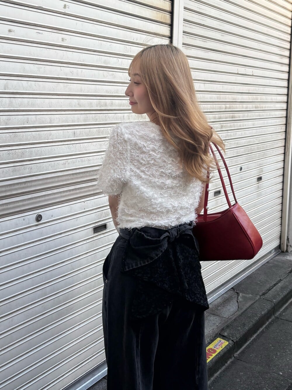 ホワイト系のサンダル、レッド系のハンドバッグ、ブラック系のデニムパンツを着用したレディースの夏コーディネートの4枚目の写真