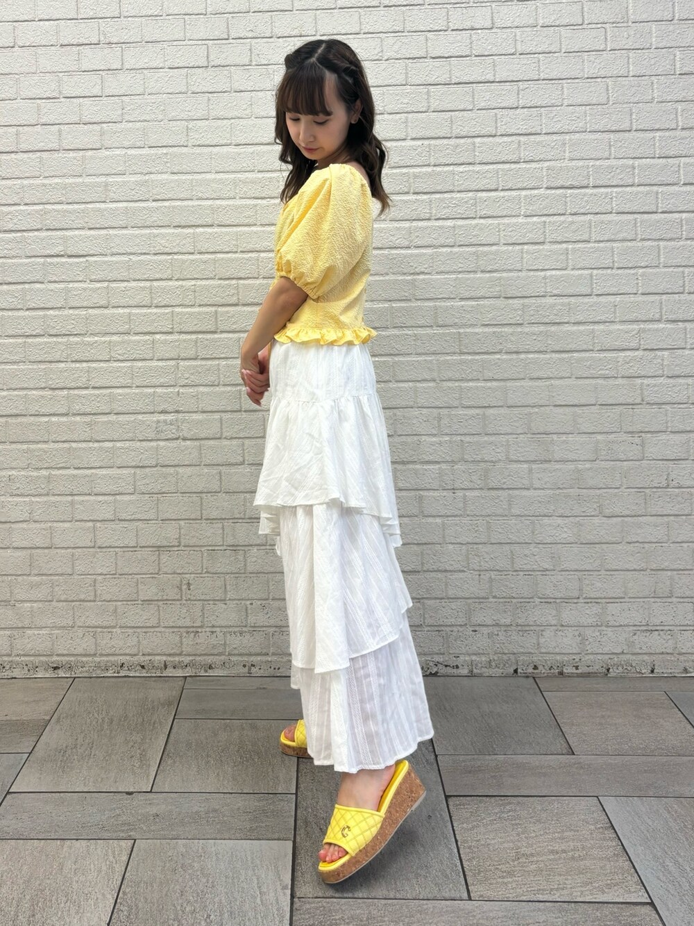 ホワイト系のスカート、イエロー系のシャツ/ブラウス、イエロー系のサンダルを着用したレディースの春コーディネートの3枚目の写真