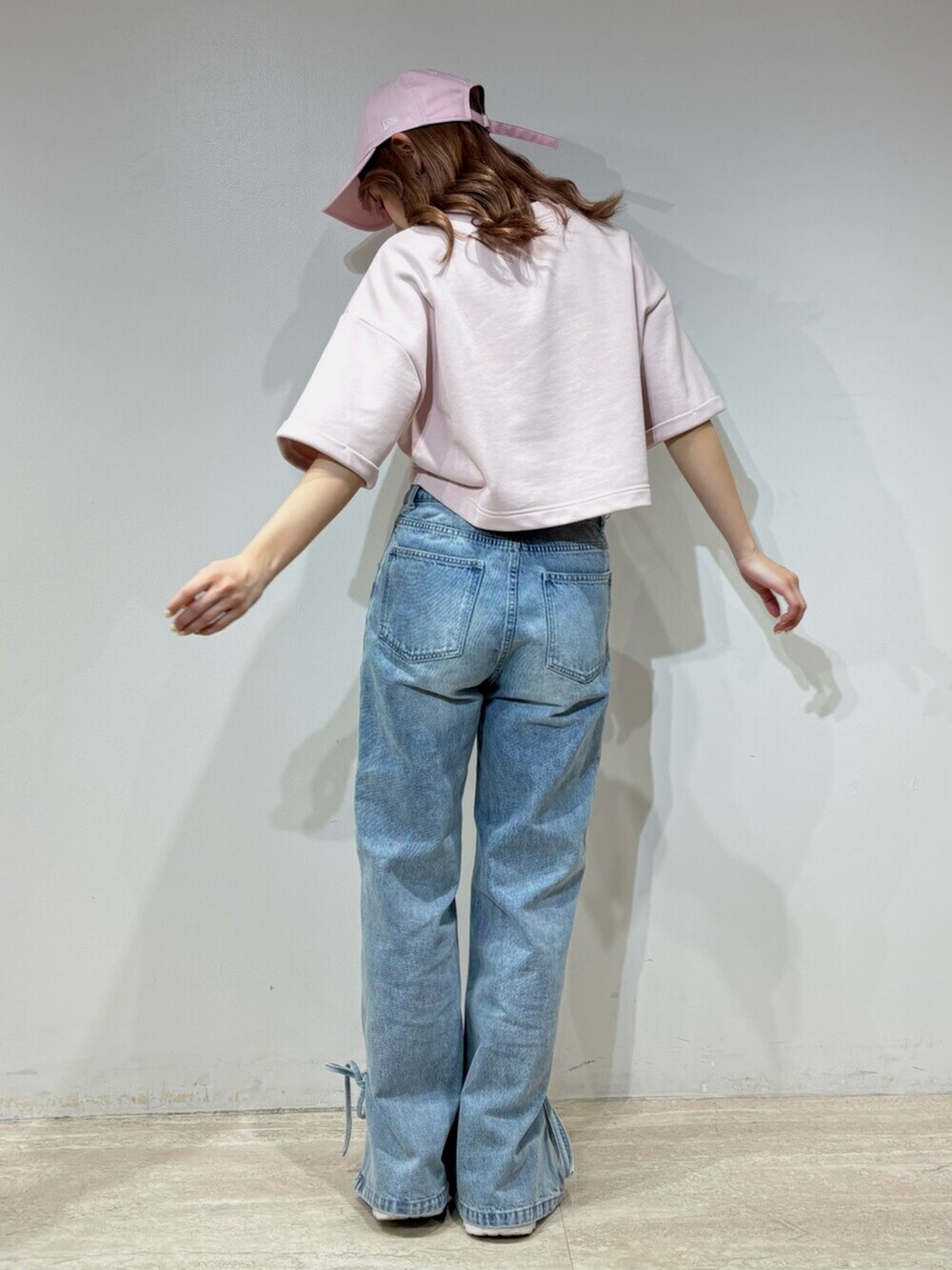 ブラック系のデニムパンツ、グレー系のスウェット、ブラック系のキャップを着用したレディースの春コーディネートの3枚目の写真