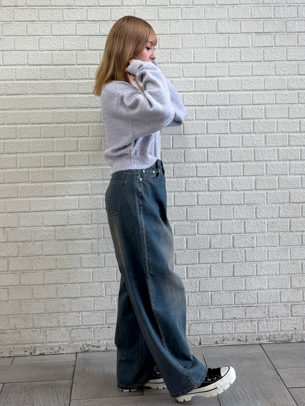 ブルー系のデニムパンツ、パープル系のニット/セーターを着用したレディースの冬コーディネートの3枚目の写真