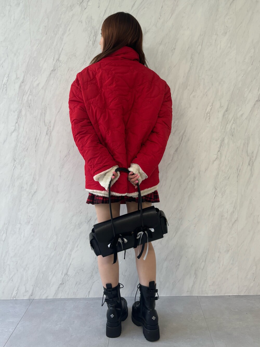 ブラック系のハンドバッグ、ブラック系のブーツ、レッド系のその他アウターを着用したレディースの夏コーディネートの4枚目の写真