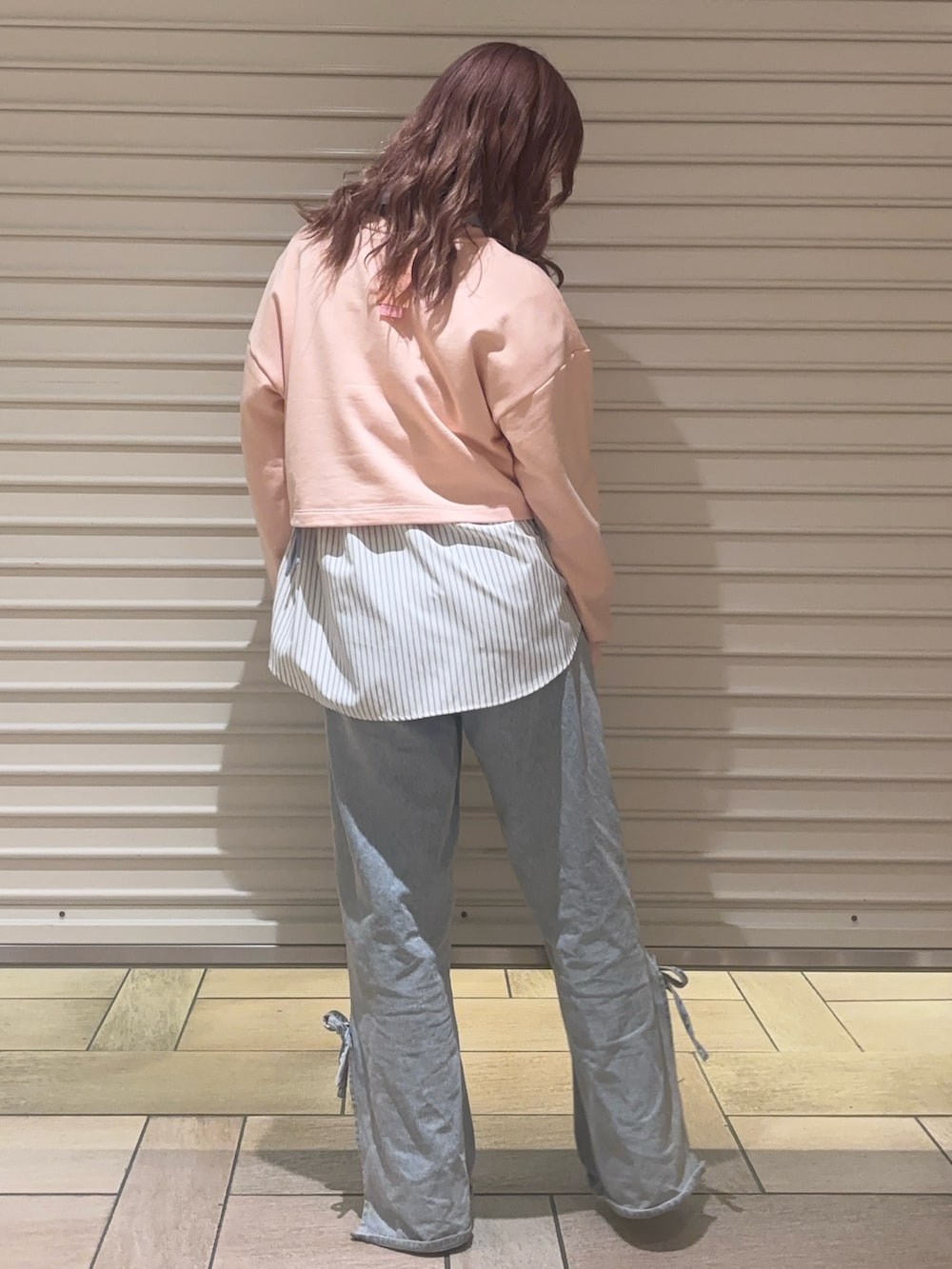 ブルー系のデニムパンツ、ブルー系のシャツ/ブラウス、ピンク系のスウェットを着用したレディースの春コーディネートの3枚目の写真