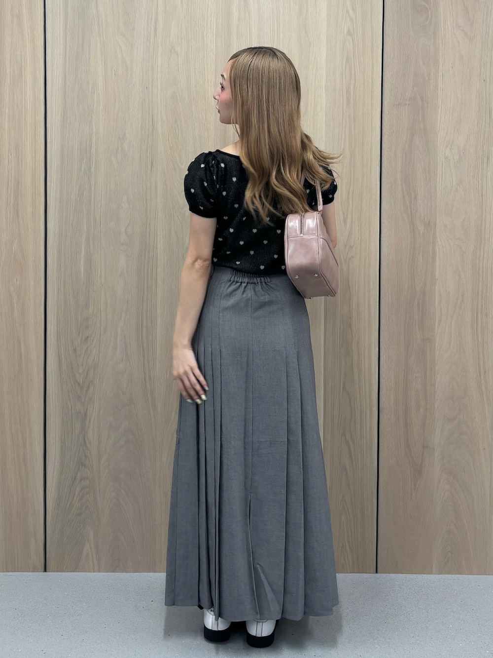 グレー系のスカート、ブラック系のTシャツ/カットソー、ピンク系のボストンバッグを着用したレディースの夏コーディネートの3枚目の写真