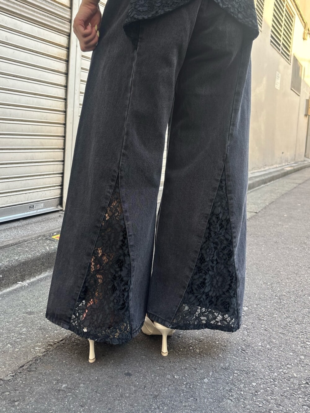 ホワイト系のサンダル、レッド系のハンドバッグ、ブラック系のデニムパンツを着用したレディースの夏コーディネートの5枚目の写真