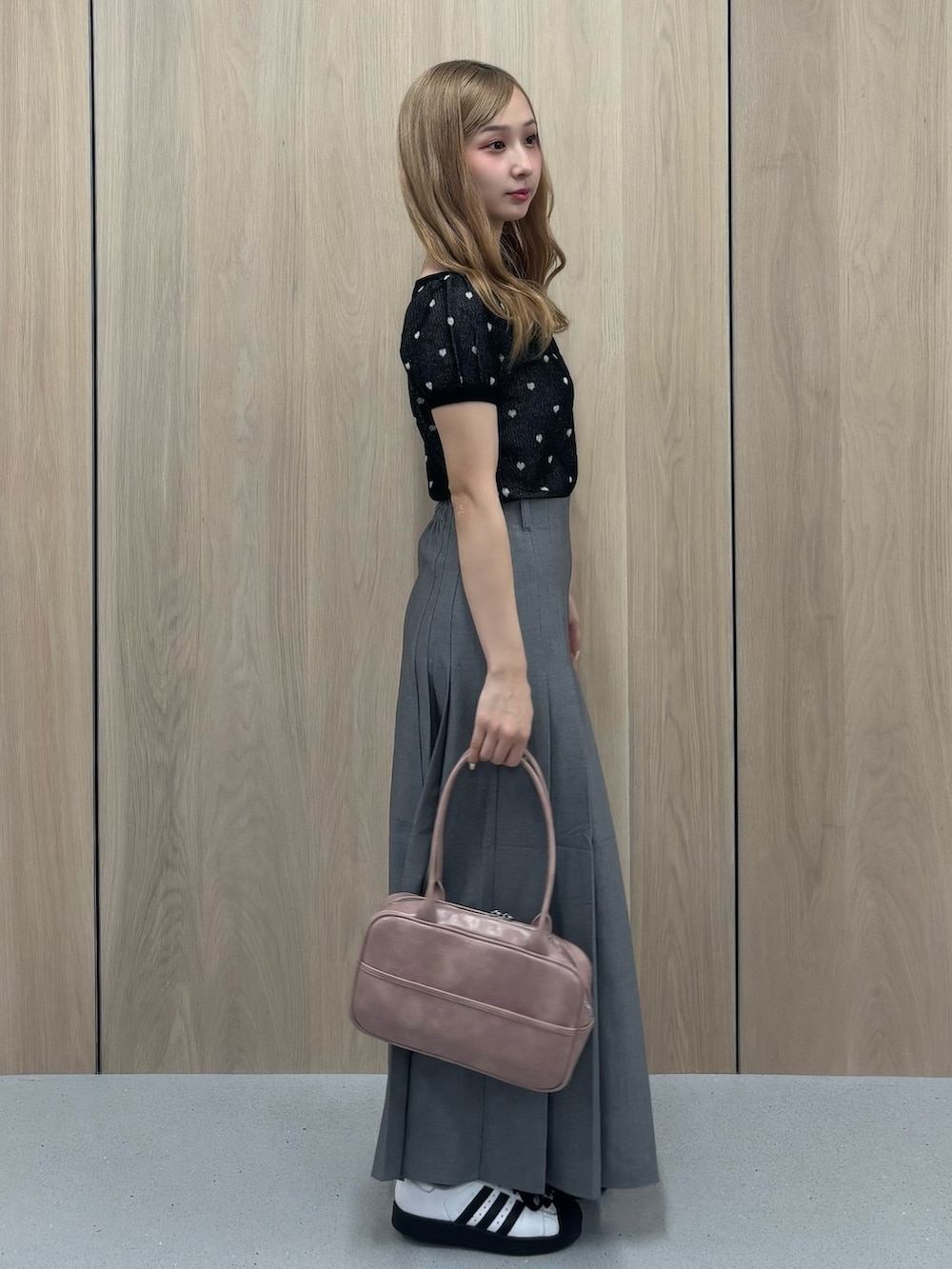 グレー系のスカート、ブラック系のTシャツ/カットソー、ピンク系のボストンバッグを着用したレディースの夏コーディネートの2枚目の写真