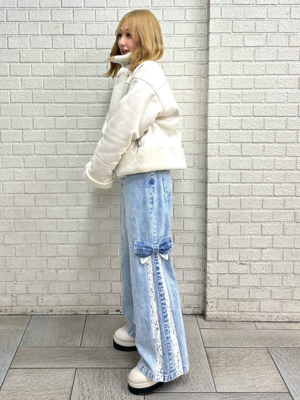 その他のブルゾン、ブルー系のデニムパンツ、ブラック系のブーツを着用したレディースの秋コーディネートの5枚目の写真