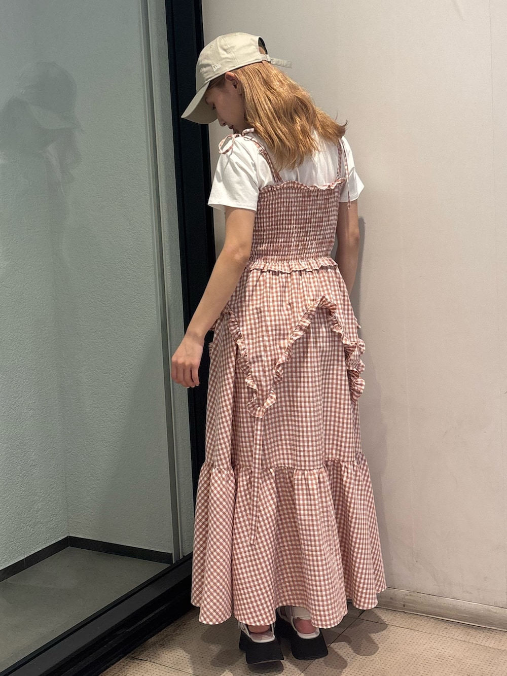 ピンク系のワンピース、ホワイト系のTシャツ/カットソー、ホワイト系のサンダルを着用したレディースの夏コーディネートの4枚目の写真