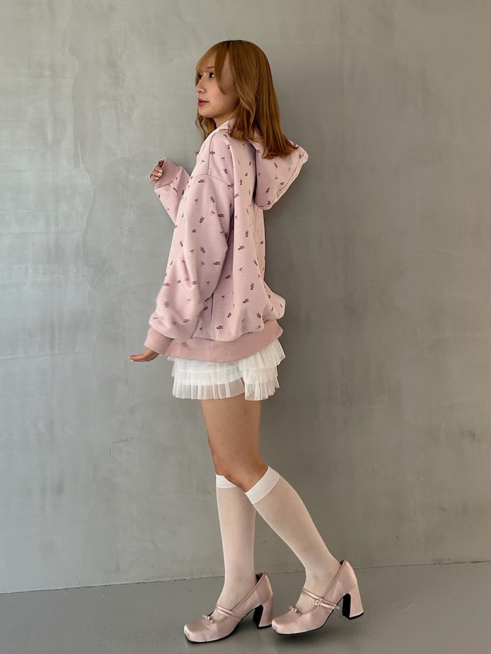 ピンク系のパーカー、ホワイト系のスカート、ピンク系のパンプスを着用したレディースの春コーディネートの4枚目の写真