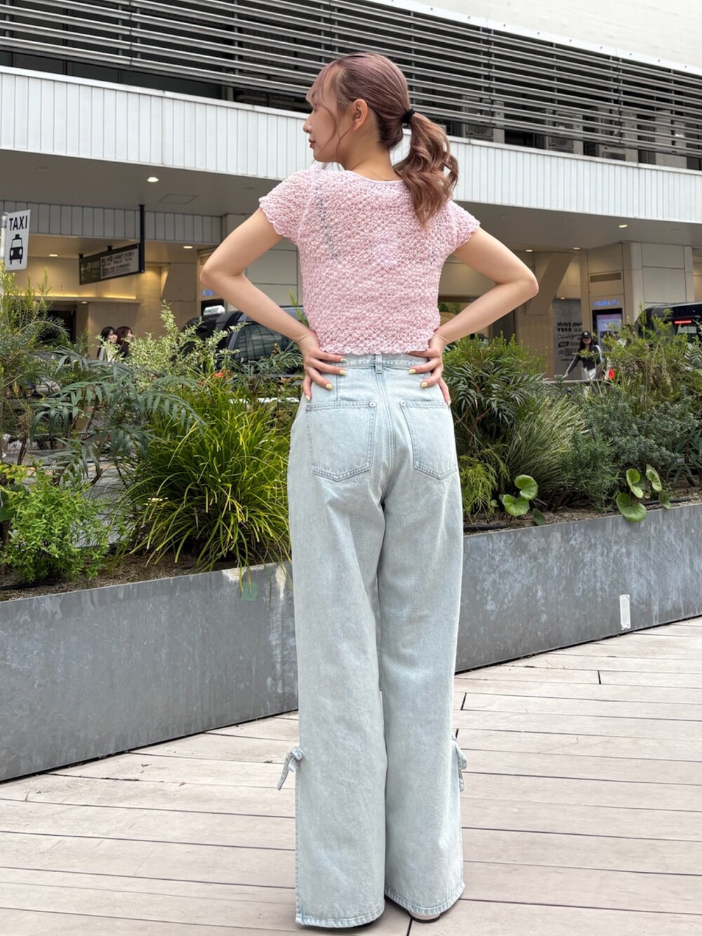 ブルー系のデニムパンツ、ピンク系のTシャツ/カットソー、ピンク系のパンプスを着用したレディースの春コーディネートの5枚目の写真