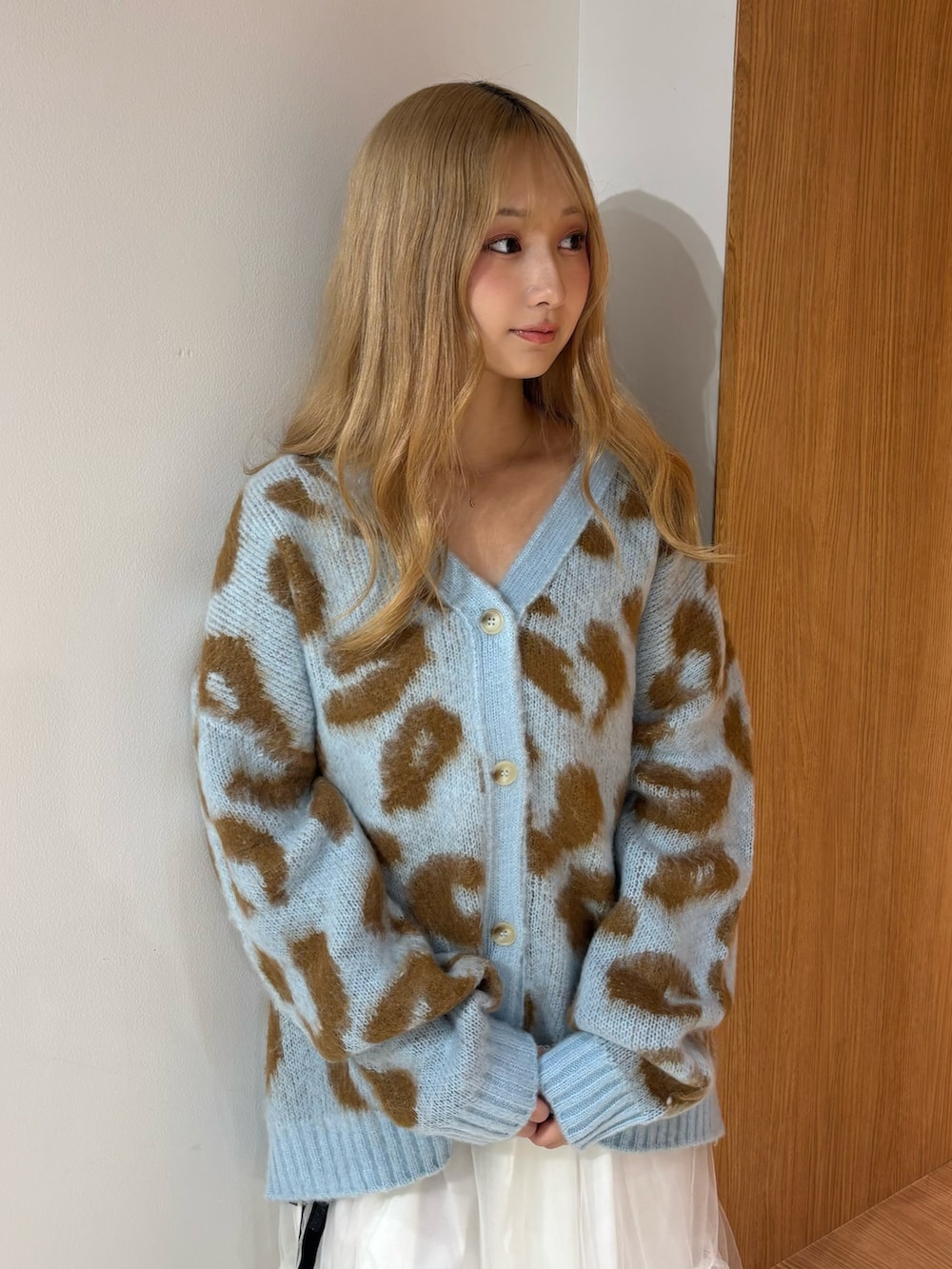 ブルー系のニット/セーター、ホワイト系のスカート、ブラウン系のブーツを着用したレディースの秋コーディネートの5枚目の写真