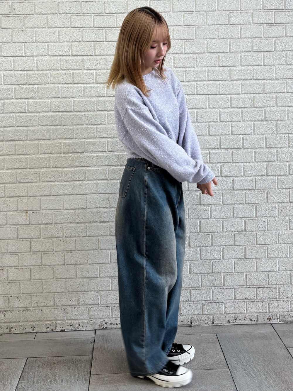 ブルー系のデニムパンツ、パープル系のニット/セーターを着用したレディースの冬コーディネートの2枚目の写真