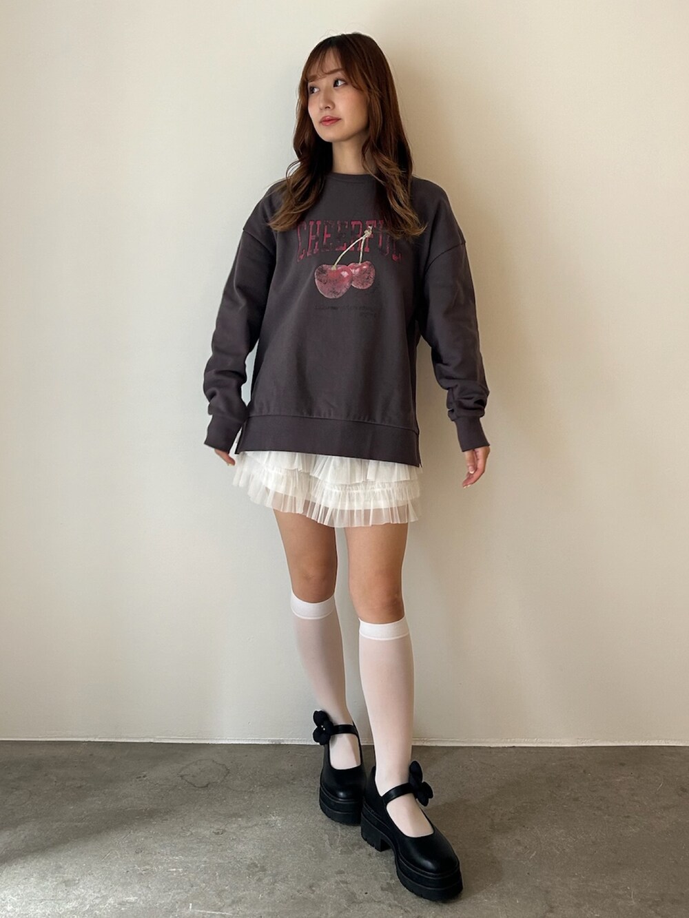 グレー系のスウェット、ホワイト系のローファー、ホワイト系のスカートを着用したレディースの秋コーディネートの7枚目の写真