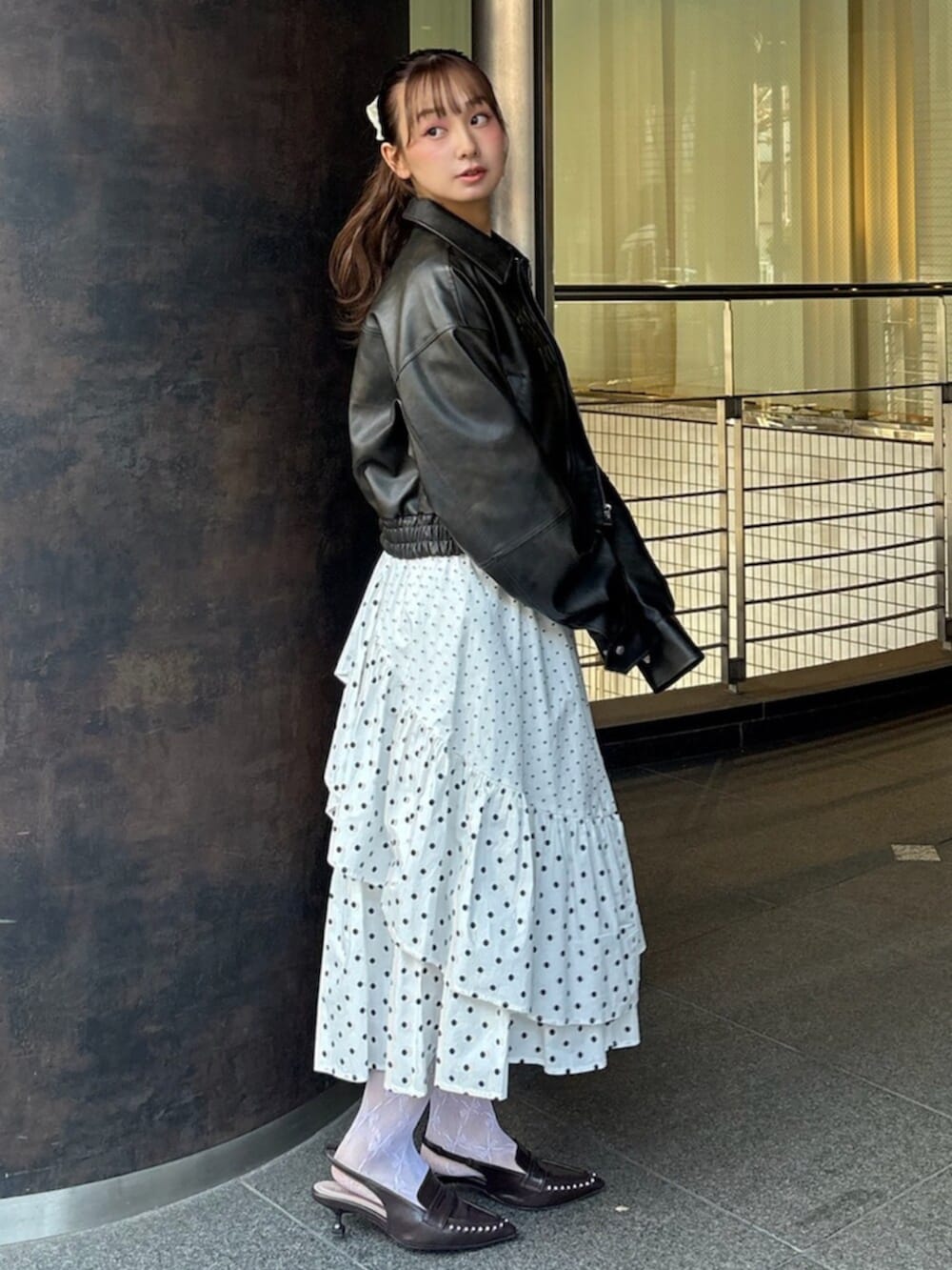 ブラウン系のブルゾン、ホワイト系のスカート、ブラウン系のサンダルを着用したレディースの冬コーディネートの2枚目の写真