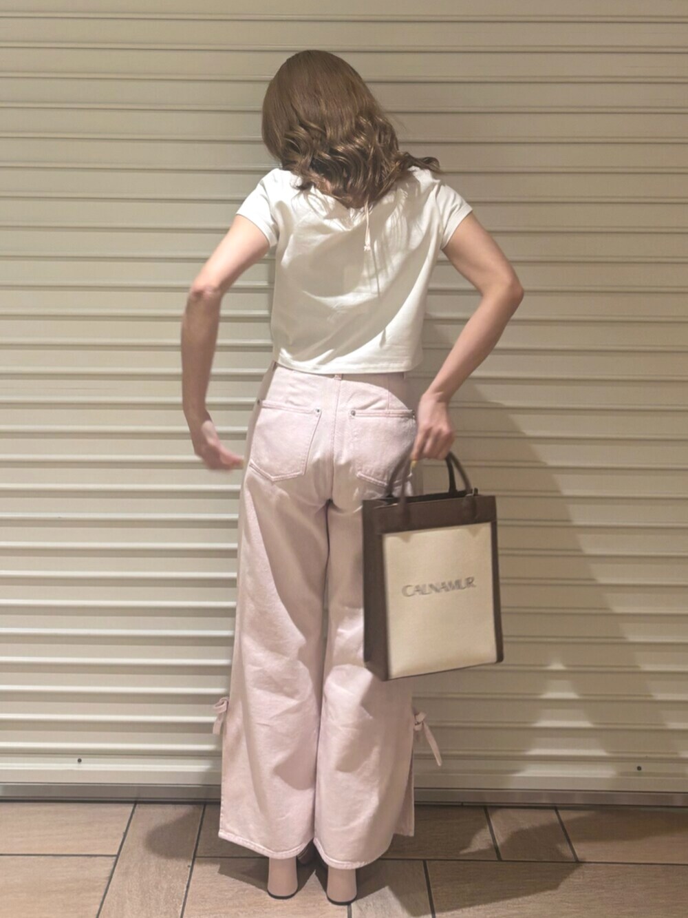 ピンク系のデニムパンツ、ピンク系のTシャツ/カットソー、ピンク系のパンプスを着用したレディースの春コーディネートの5枚目の写真