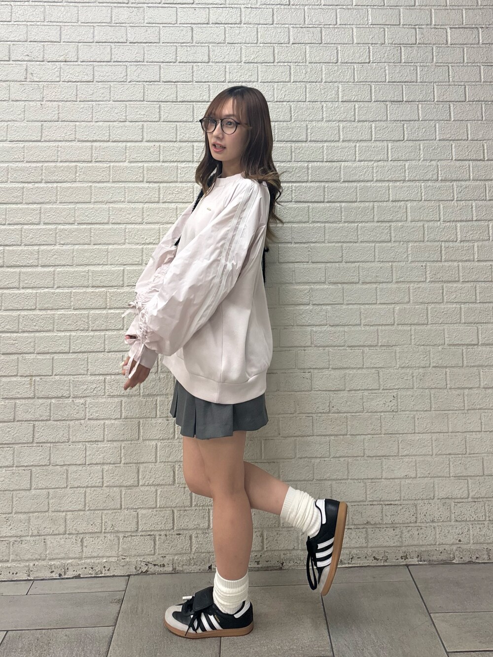 ピンク系のスウェット、グレー系のスカートを着用したレディースの秋コーディネートの2枚目の写真