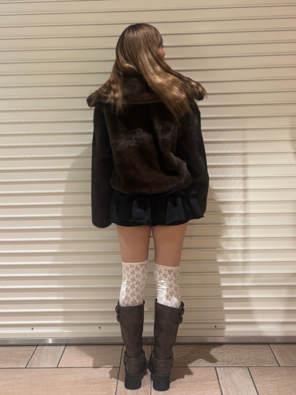 ブラウン系のブーツ、ブラック系のその他パンツ、ブラウン系のブルゾンを着用したレディースの秋コーディネートの3枚目の写真