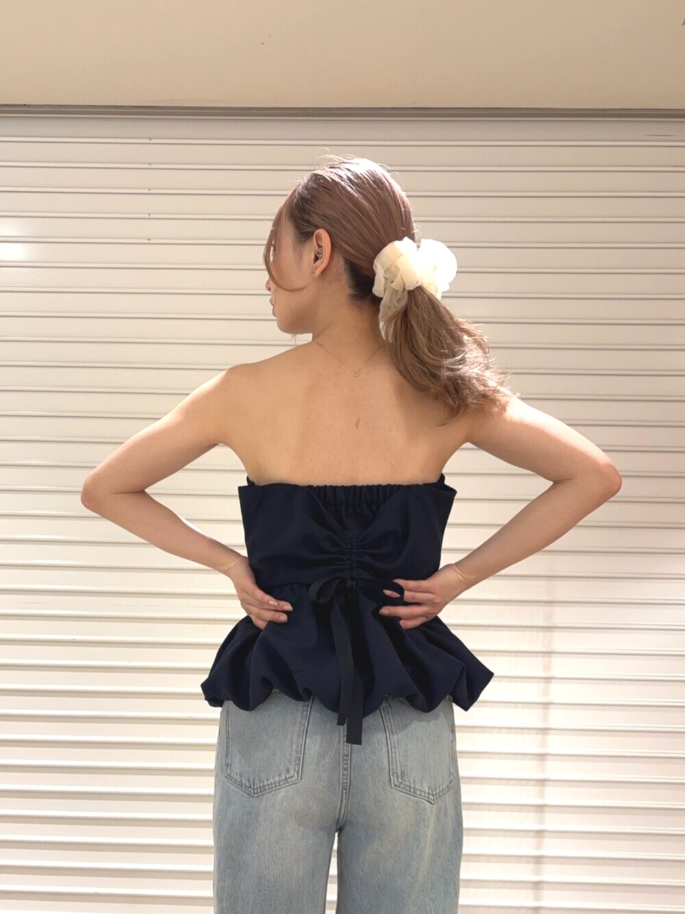 ホワイト系のカーディガン/ボレロ、ブルー系のデニムパンツ、ブルー系のチューブトップを着用したレディースの春コーディネートの7枚目の写真